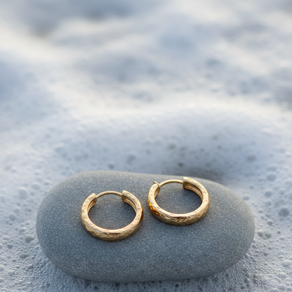 Grey pebble stone with two gold hoop earrings